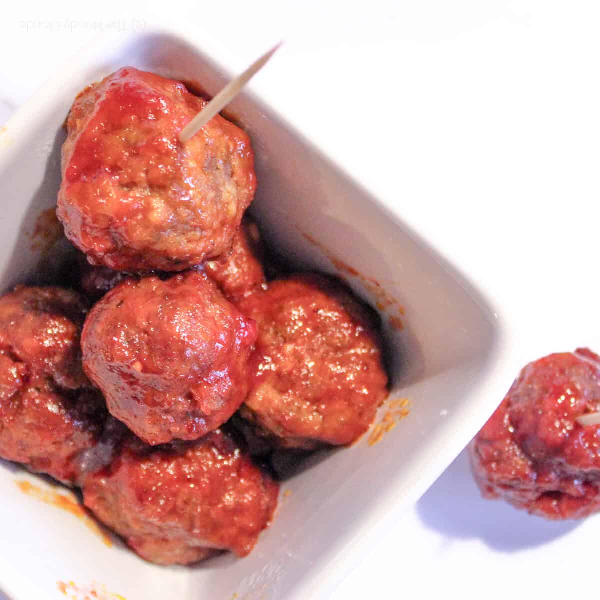 White bowl with Instant Pot cocktail meatballs held with toothpics