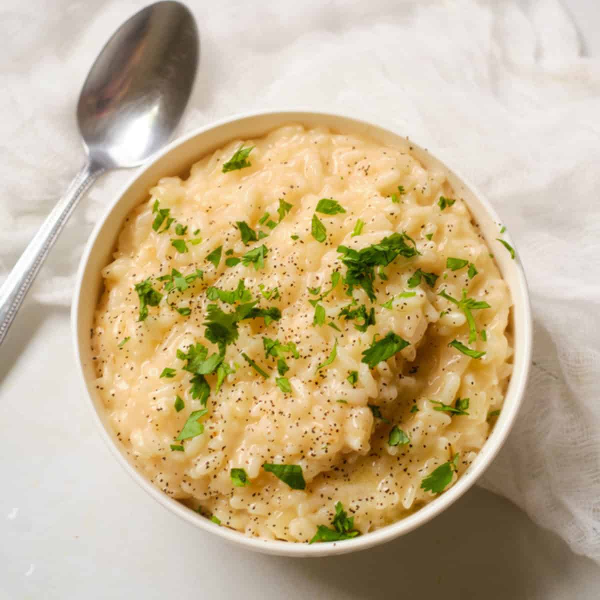 Instant Pot Lemon Risotto in a white bowl garnished with parsley